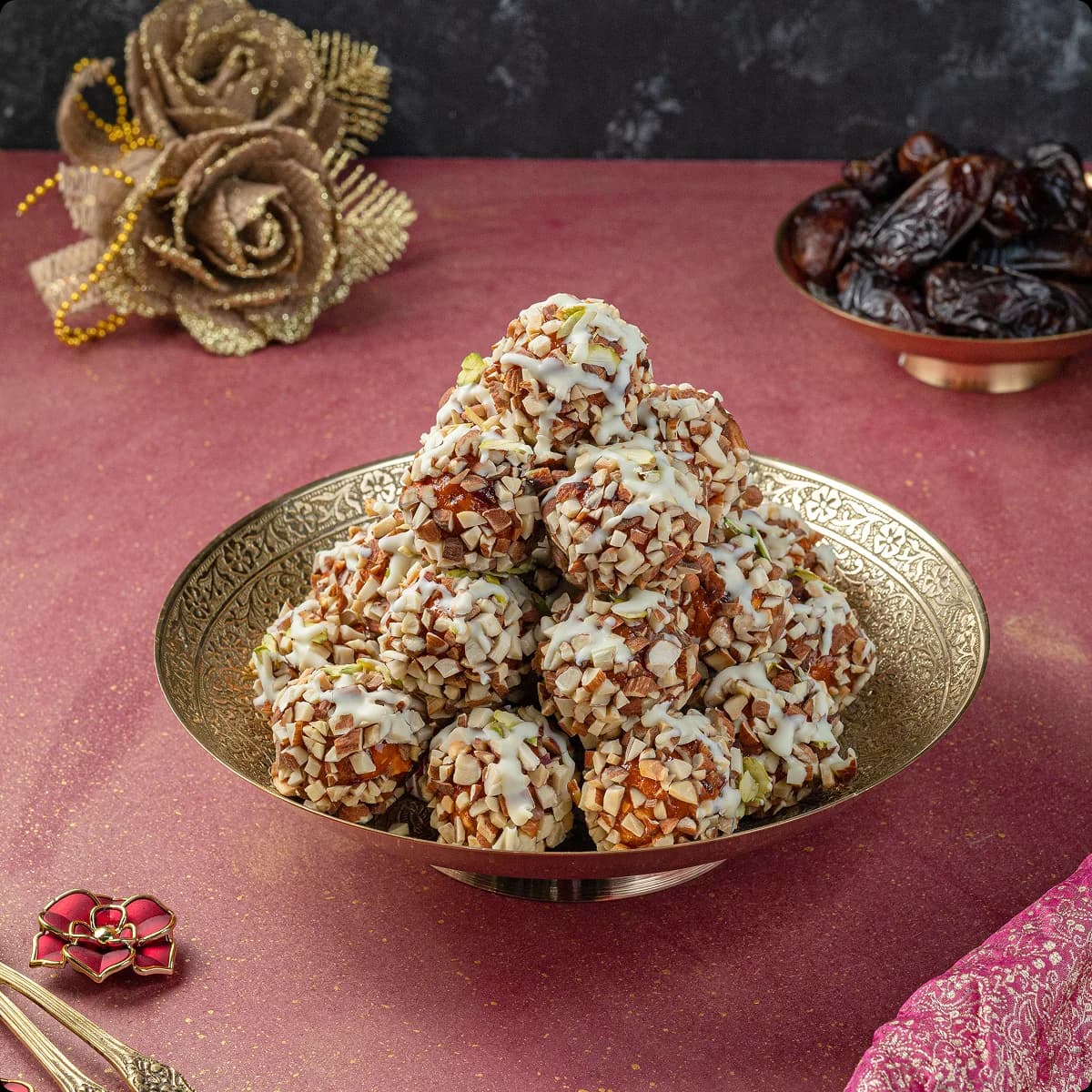A brass bowl of dry fruit laddus
